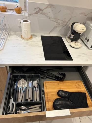 un tiroir rempli d'ustensiles au-dessus d'un comptoir dans l'établissement Appart cosy proche le havre, à Harfleur