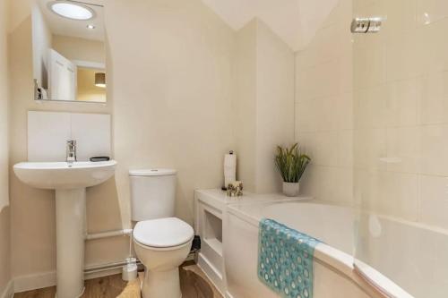 a bathroom with a toilet and a sink and a tub at 5 Tai Nantlle in Nantlle