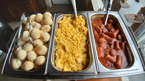 a tray of food with different types of breakfast foods at Pousada Pompeia in Socorro