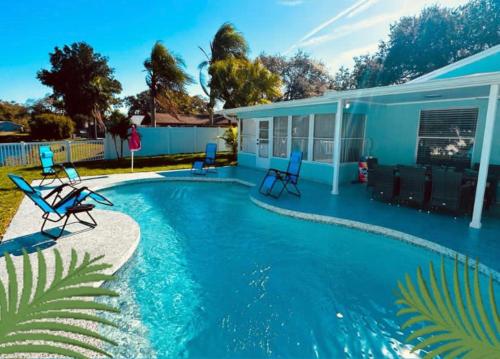 布雷登顿NEW Renovated luxury home with private heated pool, game room Near Anna Maria Island and IMG的带椅子的游泳池和一栋房子