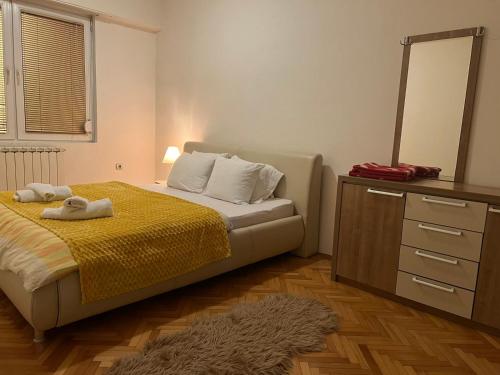 een slaapkamer met een bed en een dressoir met een spiegel bij Apartman Mila in Usje