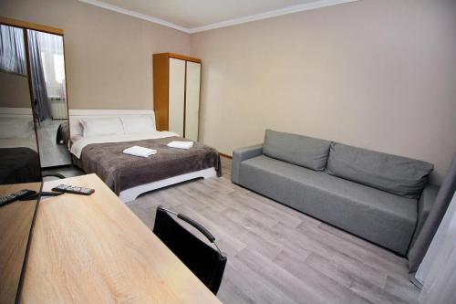 a hotel room with a bed and a couch at На бульваре Мендикулова in Almaty