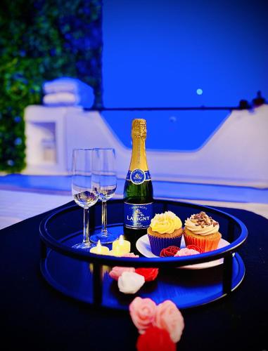 a table with a bottle of champagne and cupcakes at Suite in the City avec JACUZZI PRIVATIF - Hyper Centre in Montpellier