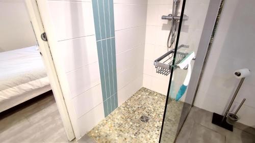 una ducha con puerta de cristal en un baño en Les Ecureuils Du Parc à 400 m de la plage, en Royan