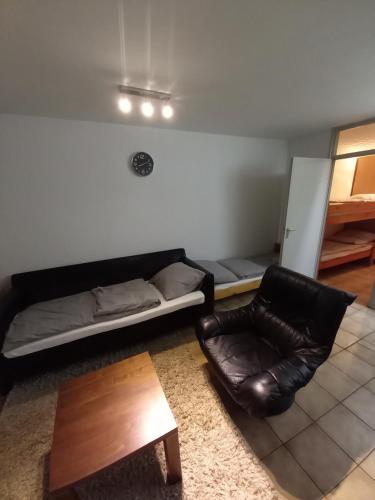 ein Wohnzimmer mit einem Sofa und einem Stuhl in der Unterkunft Ap22 Nature Ardennes Economy class apartment in La Calamine