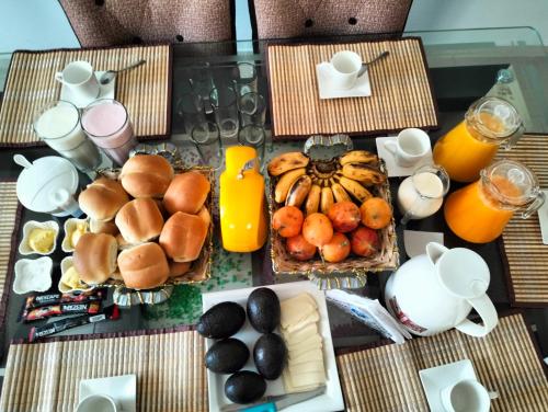 a table topped with breakfast foods and orange juice at Alemar's House in Nazca