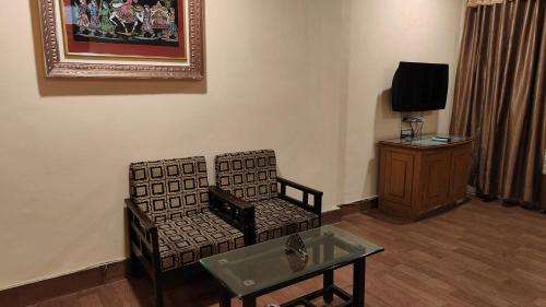 a living room with a chair and a table at Hotel Vandana in Kota