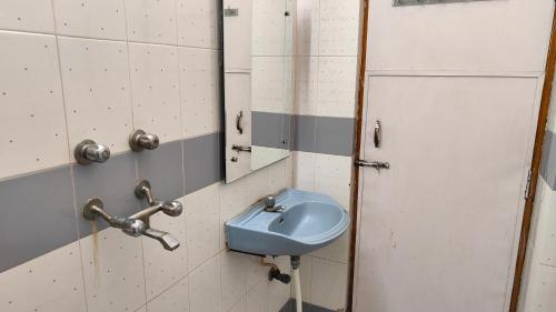 a bathroom with a blue sink and a mirror at Hotel Vandana in Kota