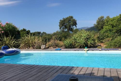 une piscine avec une terrasse en bois et une piscine dans l'établissement Maison entre mer et montagne, à Lecci