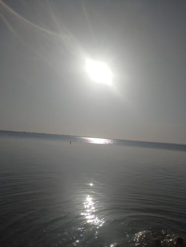 un cuerpo de agua con el sol en el fondo en Sol e mar, en Iguaba Grande