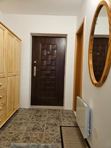 pasillo con puerta marrón y espejo en Apartmán Julie, en Rokytnice nad Jizerou