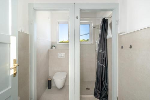 a bathroom with a toilet and a window at Authentic house in Dubrovnik
