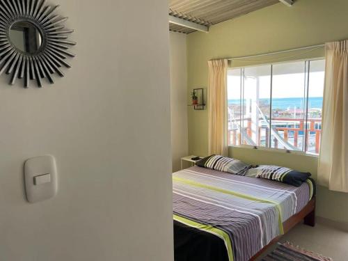 um quarto com uma cama com uma janela e um espelho em CASA GRAU - ZORRITOS em Caleta Grau