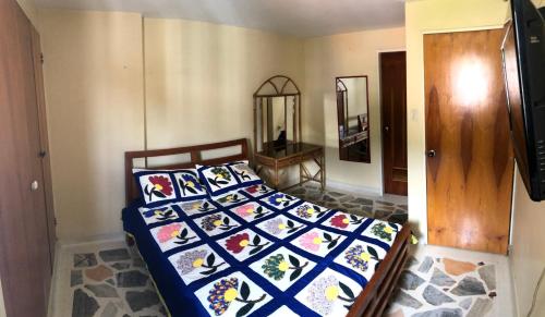 een slaapkamer met een bed met een quilt bij Confortable Apartamento in Mérida