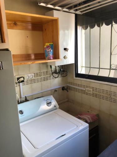 una pequeña cocina con fregadero y lavadora en Confortable Apartamento, en Mérida