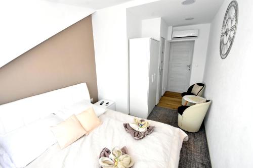 a bedroom with a large white bed and a chair at Villa Sovita in Łeba