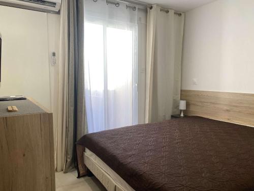 une chambre avec un lit et une grande fenêtre dans l'établissement Appartement T2 rénové avec climatisation et internet, proche centre et étang de Thau - FR-1-553-193, à Balaruc-les-Bains