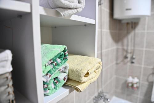 een stapel handdoeken op een plank in een badkamer bij Apartman Iva in Bijeljina