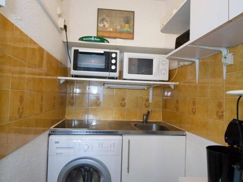 une cuisine avec un lave-linge et un micro-ondes dans l'établissement Beau T2 avec Parking, Clim et Wifi - Balaruc-les-Bains - FR-1-553-186, à Balaruc-les-Bains