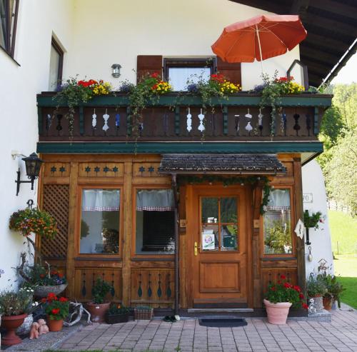 a building with a wooden door and an umbrella at Frühstückspension Pachler in Gosau