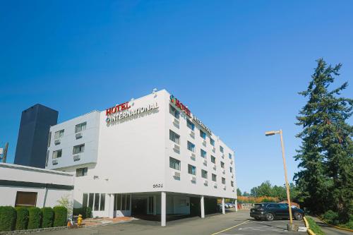 a white building with a sign on the top of it at Hotel International in Lynnwood