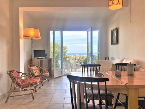 un salon avec une table et des chaises et un balcon dans l'établissement Appart. moderne au calme - Bormes-les-Mimosas - WIFI, AIRCONDITIONING, PARKING - FR-1-251-461, à Bormes-les-Mimosas