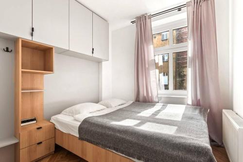een slaapkamer met een groot bed en een raam bij Stylowy apartament z osobną sypialnią Powstańców4a in Katowice