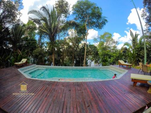 einen Pool auf einer Holzterrasse mit einem Kind im Wasser in der Unterkunft Amazon Premium Lodge in Careiro
