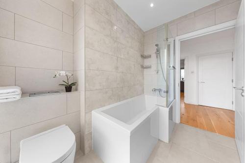 a white bathroom with a toilet and a sink at Luxury Central London Apartments Bermondsey in London