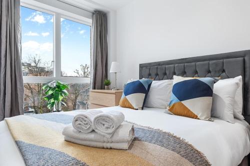 a bedroom with a large bed with a large window at Luxury Central London Apartments Bermondsey in London