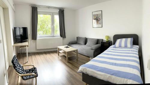 niewielka sypialnia z łóżkiem i kanapą w obiekcie Easy to Düsseldorf Messe, 2-bedroom Apartment with kitchen and garden w mieście Duisburg