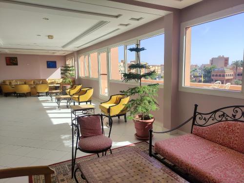 une salle d'attente avec des chaises jaunes et un canapé dans l'établissement Hotel Idou Tiznit, à Tiznit