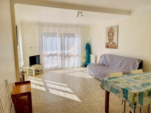 un salon avec un lit et une télévision dans l'établissement Appartement F2 avec Terrasse et Parking, Proche Cures et Centre-ville - Amélie-les-Bains - FR-1-703-142, à Amélie-les-Bains-Palalda