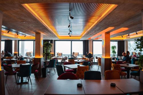 a restaurant with tables and chairs and people sitting at tables at Mamababa FREE SPA & Wellness Kopaonik in Kopaonik