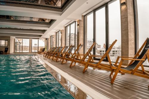 a row of chairs in a pool with windows at Mamababa FREE SPA & Wellness Kopaonik in Kopaonik