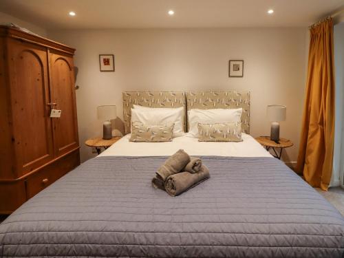 a bedroom with a large bed with a stuffed animal on it at Mistletoe Cottage in Bamburgh