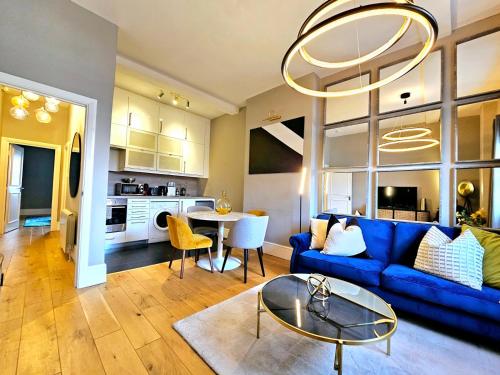 sala de estar con sofá azul y mesa en Gorgeous Hyde Park Home with Elevator Access by Tube Metro Stations, en Londres