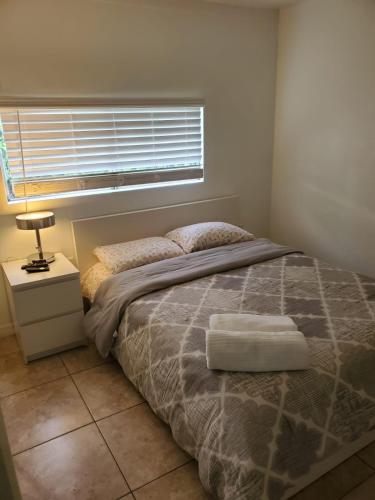 a bedroom with a bed and a window and a lamp at 13101 Main Home Miami in Miami