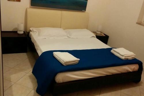 1 dormitorio con 1 cama con 2 toallas en VILLA 100 steps seaside in SALENTO, en Torre Canne