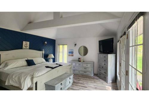 a bedroom with a large bed and a television at Prince Edward County~Water View~FREE Pontoon Boat~Sandbanks Pass in West Lake