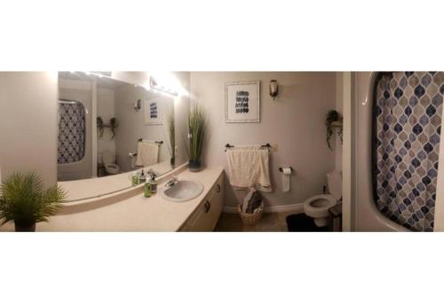 a bathroom with a sink and a large mirror at Prince Edward County~Water View~FREE Pontoon Boat~Sandbanks Pass in West Lake