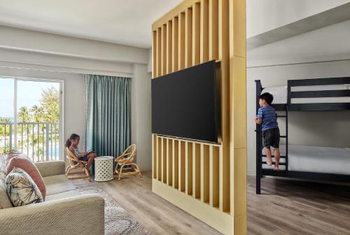 ein Kind steht in einem Schlafzimmer mit Etagenbett in der Unterkunft Crowne Plaza Resort Saipan in Garapan