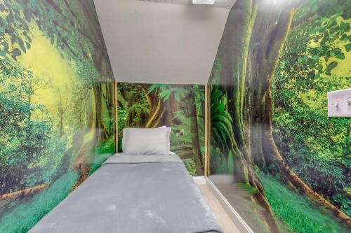 a bedroom with a jungle mural on the wall at Bare Assets in Pigeon Forge