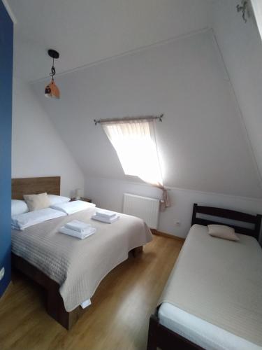 2 Betten in einem Zimmer mit Fenster in der Unterkunft Pensjonat Hagi in Horyniec
