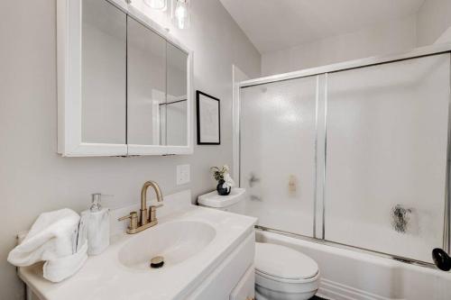 Un baño blanco con lavabo y ducha. en Cozy Henderson Home Close to Downtown Henderson, en Henderson