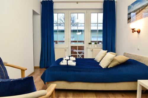 Schlafzimmer mit blauem Bett und blauen Vorhängen in der Unterkunft Dom Wczasowy Chlapovia in Władysławowo