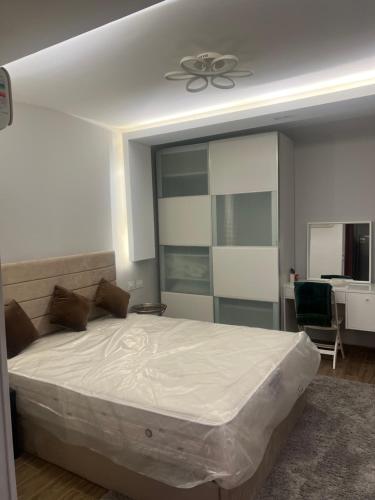 a bedroom with a large bed with a ceiling fan at Nice Studio on the Roof in Sheikh Zayed