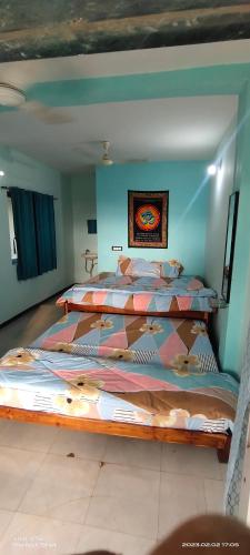 um quarto com duas camas e um quadro na parede em Tapsya Beach Cafe em Murūd
