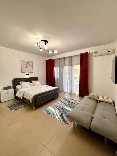 una camera con due letti e un divano in camera di Le Dakar Roi - Studio Centre Ville Très Bien Situé a Dakar