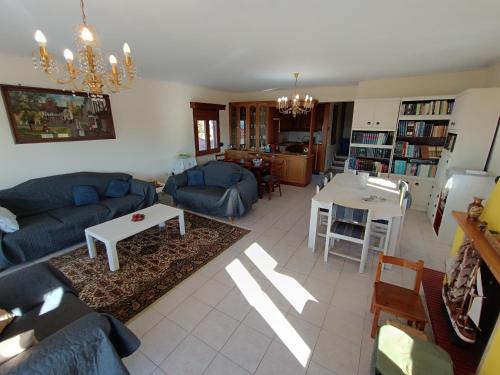 uma sala de estar com um sofá azul e uma mesa em villa panorama seaview em Tessalónica